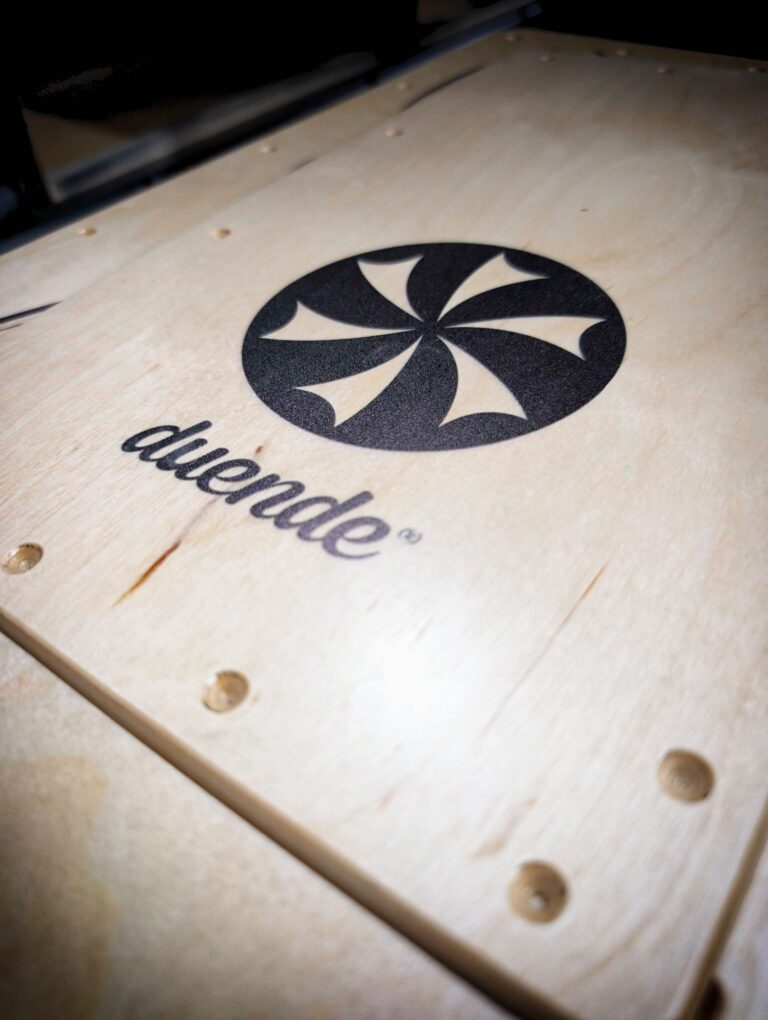 Logo de Duende Percusión impreson en el panel del cajón flamenco